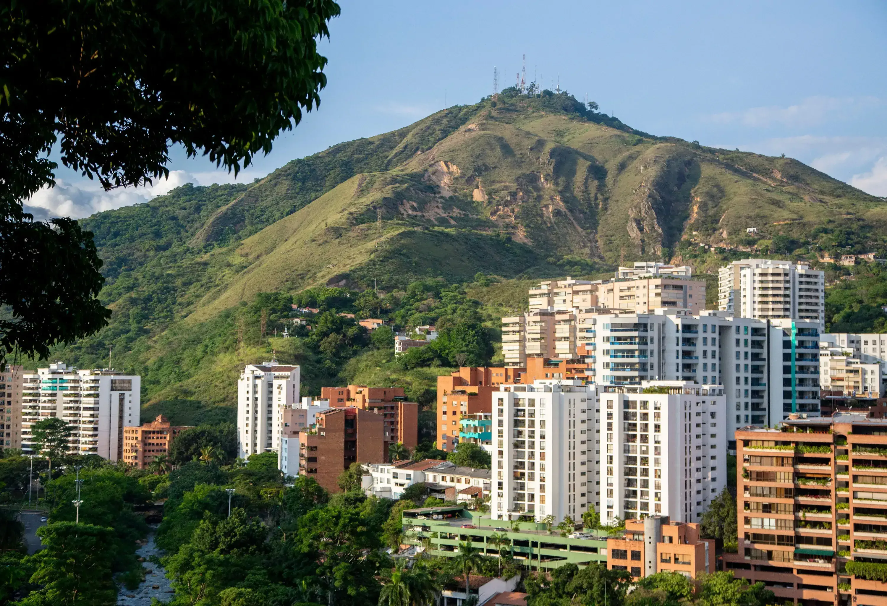 A cluster of high-rise buildings at the base of a mountain.
